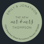 Newlyweds Return Namn Adress Sage Grönt Runt Klistermärke<br><div class="desc">Ett modernt, helt typografiskt anpassade med namn böjd över och returadressen böjd nedanför och text i mitten, New Mr och Mrs och ditt gifta namn i svart på en sage grönt bakgrund. All text kan vara enkel personlig. Du kan också ändra bakgrund och färg så att det stämmer överens med...</div>