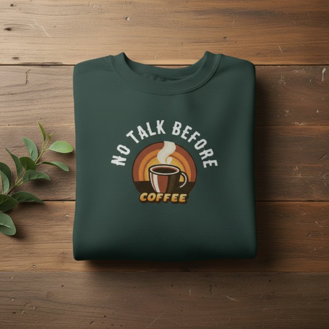No Talk Before Coffee • Funny Coffee Lover Lång Ärmad Tröja (folded dark green No Talk Before Coffee sweatshirt on wooden background with leaves)