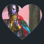 NORA CYBER WARRIOR OCH MACAW SCIENCE FICTION HJÄRTFORMAT KLISTERMÄRKE<br><div class="desc">Svart tatuerad skönhet med elegant gyllene smycken med hennes färgade röda papegoja,  under rosa kosmisk himlar med blå planeter.Konstnärlig animering ram från Hyperion World 3d animation sci-fi-film .</div>
