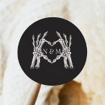 NOVA Halloween Skeleton Heart Händer Bröllop Runt Klistermärke<br><div class="desc">NOVA-samlingen "Til Death Bröllop Collection" har grafitgrafitfärgade blommigtar,  gotiska döskallar och skelett med ett festive Halloween-inspirerat typsnitt. Den här samlingen är perfekt för edgy fallpar. Köp den fullständiga samlingen för en händelse som ska imponeras.</div>