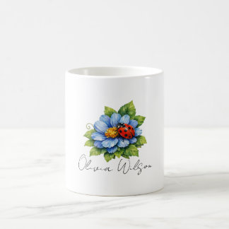 Nyckelpiggslycka på en blommande blå blomma kaffemugg