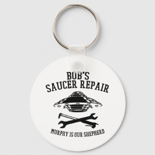 nyckelring med svart Bob's Saucer Repair-logotyp