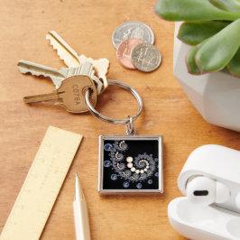 Nyckelringen Spiral i Elfenbenskusten och Blå pärl Fyrkantig Silverfärgad Nyckelring