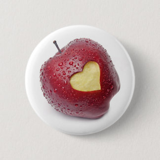 Nytt rött äpple med ett hjärtformade symbol knapp