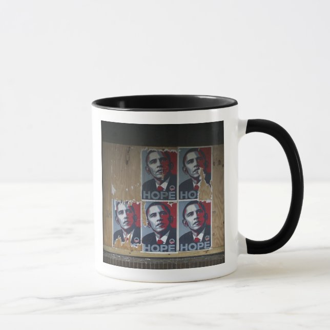 Obama signerar i ett igenbrädat fönster på en stän mugg (Höger)
