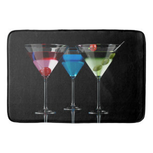 Olika cocktails i martini-glas på svart badrumsmatta