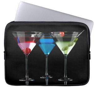 Olika cocktails i martini-glas på svart laptop fodral