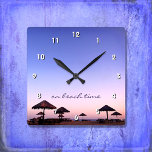 Om Beach Time California Lila Rosa Sunset Photo Fyrkantig Klocka<br><div class="desc">"På strandtid." En lila blå och rosa solnedgång på en sydlig kalifornien-strand med den där palapasoslen gör avspänning och reflexion. Slappna av, lukta havet luft och minnas sommarminnen när du tittar på chicen, snyggten, fotografiväggsklockan. Du kan välja mellan en rund eller fyrkantig klocka ansikte. Gör en underbar hemmavärmargåva! Du kan...</div>