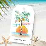 Ön Handflatan Tropical Beach-jul Presentetikett<br><div class="desc">Märkrna med de tropiska teman på stranden har en ö i sol med en handflatan-träd som är dekorerad med ljus och prydnadsföremål,  en "glad helg"-hälsning. och en textrad som du kan anpassa. Art av KL Lagrar</div>