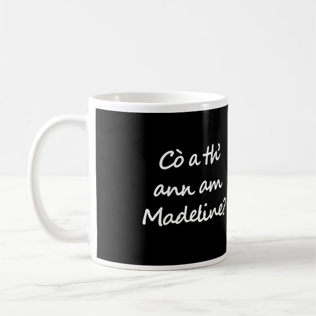One side of the mug says Cò a th' ann am Madeline? Kaffemugg (Vänster)