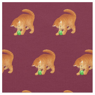 Orange kattunge som leker med bolltyg tyg