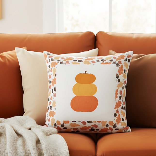 Orange staplade pumpor gårdshus höstdekor kudde (Autumn pumpkin pillow with leaf pattern brings charm to a cozy warm-toned sofa.)