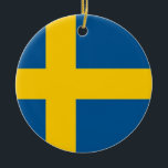 Ornament med flagga av Sverige<br><div class="desc">Fira julhelgen med vår festliga julprydnad med flagga Sverige! Detta prydnadsföremål, som utformats med stor uppmärksamhet, betalar heder åt Sverigens kulturarv och rik. Sverigens flagga visas stolt, med ett blått fält med gulten Skandinaviskt kor, som symboliserar Sverigens historiska och kulturella band till den nordiska regionen. Oavsett om du lägger till...</div>