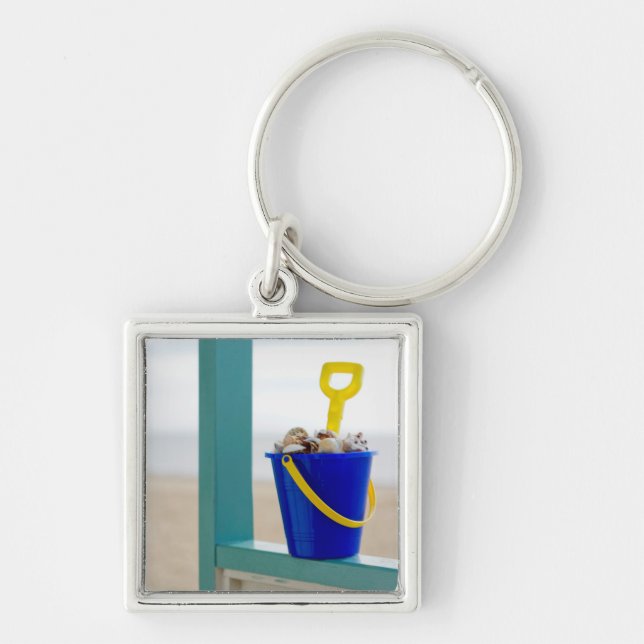 Ösregna fyllt med snäckskal fyrkantig silverfärgad nyckelring (Framsidan)