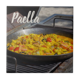Paella är kokt på en grillgåva till kock kakelplatta