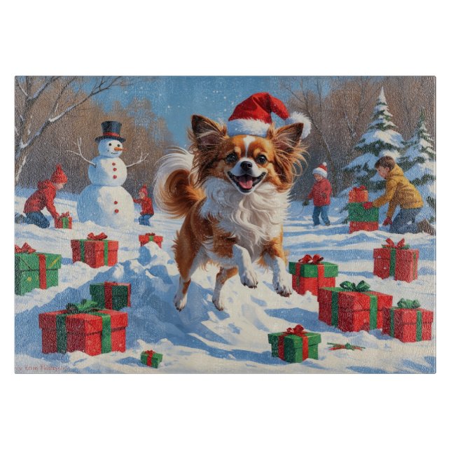 Papillon-hund springer i snö med julhatt (Framsidan)