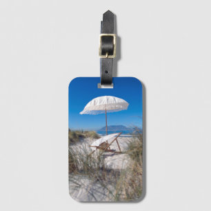 Paraply och stol på strand bagagebricka