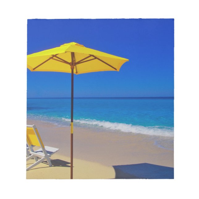 Paraply och stolar på stranden i gult på pristin anteckningsblock (Framsida)