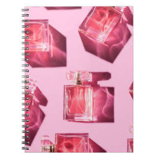 Parfym flaskor, rosa bakgrund, flatlay anteckningsbok