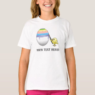 Påskkyckling målar ett färgglatt påskägg t shirt