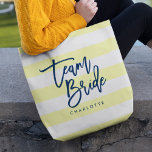 Pastel Gult och White Rand Blue Team Bride Tygkasse<br><div class="desc">Hela-over-Print-toteväska med ord "Team Bride" i blått trendig-skript mot en pastellbakgrund och vit rand mönster-bakgrund. Perfekt till bröllop för brudgummar, maid of honor och blomsterflicka. Om du vill ha mer färg och matchande objekt kan du gå till https://www.zazzle.com/collections/119250194970828530?rf=238364477188679314 Anpassa den genom att ersätta platshållartexten. Om du vill ha fler alternativ...</div>