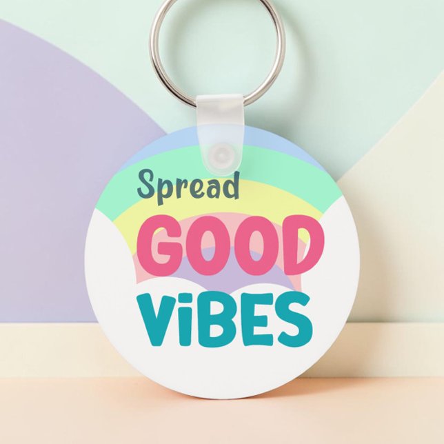 Pastell Regnbåge Sprider Goda Vibrationer Citat Nyckelring (Spread Good Vibes pastel rainbow keychain in a r ound chape against a pastel painted background.)