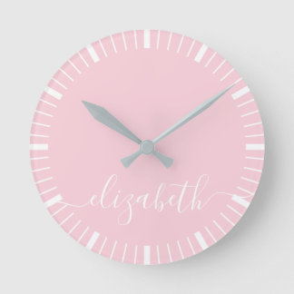 pastellrosa med vit script-signatur - minimal rund klocka