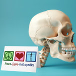 Peace Kärlek Orthopedics Helgkort<br><div class="desc">Freden Kärlek Orthopedics är närvarande. En söt julklapp till en ortopedisk kirurg eller ortopedist som arbetar med muskuloskeletala systemet och patienter som behöver skuldra- och höftkirurgi. Ett fredstecken,  ett hjärta och ett skelett för att visa specialitetens ben.</div>