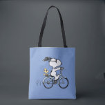 Peanuts | Snoopy & Woodstock Bicycle Tygkasse<br><div class="desc">Pedal into style and classic charm with this adorable cream canvas tote bag, featuring Snoopy and Woodstock on a bicycle! This fun tote showcases a delightful line-art illustration of Snoopy, wearing sunglasses, happily riding a vintage-style blue bicycle with Woodstock perched safely behind him. The dashed lines behind the back wheel...</div>