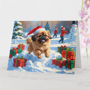 Pekingeserhund springer i snö med julhatt kort