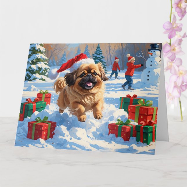 Pekingeserhund springer i snö med julhatt kort (Orkide)