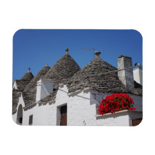 Pelargonblommor och trullihus i Alberobello Magnet
