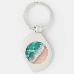 Persikohavet vatten på sommaren med kustsand swirl silverfärgad nyckelring