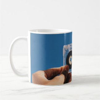 Person som håller vitt och svart kassettband kaffemugg
