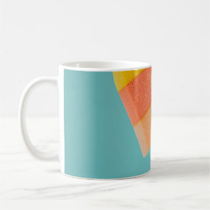 Person som innehar gult och rosa kaffemugg