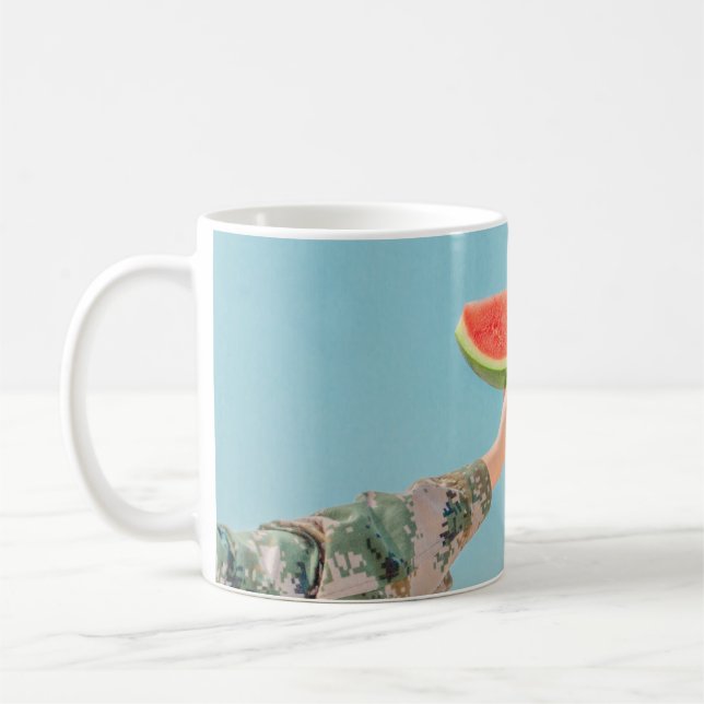 Person som innehar segmenterad vattenmelon kaffemugg (Vänster)