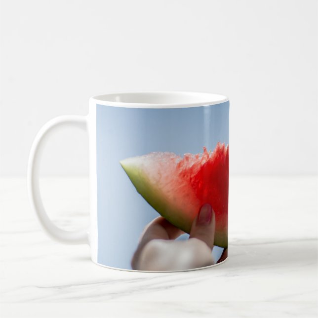 Person som innehar segmenterad vattenmelon kaffemugg (Vänster)