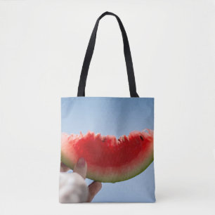 Person som innehar segmenterad vattenmelon tygkasse