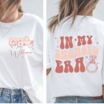 Personlig i min engagerade era framtida Mrs. T Shirt<br><div class="desc">Firar hennes nästa kapitel med Perfekt Förlovning Gift! Gör den blivande bruden i extra speciell med denna mysiga och snyggt anpassningsbar "Framtidens fru". T-shirt - en must-have för varje fästmö som kommer in i hennes bröllop-era! På skjortans framsida står stolt "Framtida fru" bredvid anpassadet... nytt efternamn, vilket gör det till...</div>