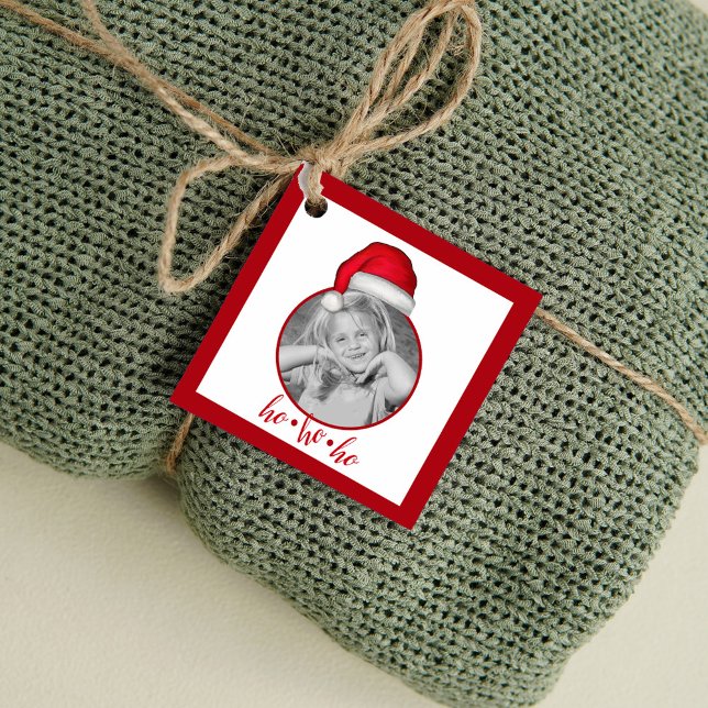 Personlig jultomtelua julen firande gåvor etiketter (Personalized Christmas gift tag with photo and Santa hat design tied to wrapped holiday gift.)
