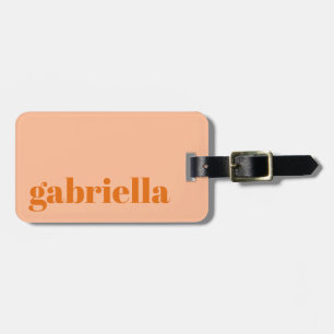 Personligt namn med fet typografi i persikorange bagagebricka