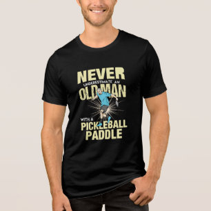 Pickleball - gammal man med en pickleball-sadel t shirt