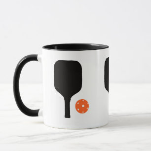 Pickleball paddle och orange pickleball mugg
