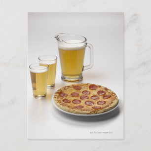 Pitcher och två pint öl bredvid pepperoni vykort