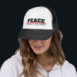 PIWNEED PEACE KEPS<br><div class="desc">Truckerkeps svart och vit med "Peace IS WTHE WE", med en bred röd linje under Peace, även med I-BONE LTD. vid grund. Det verkar som om freden har hämtats från oss. Krig eller hotet från krig finns överallt.</div>