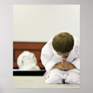 Pojke (4-5 år) med karatutrustning, bowing. poster
