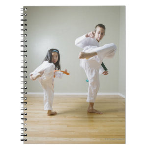 Pojke och flicka (4-9) praktisera Taekwondo Anteckningsbok