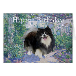 Pomeranian i blomsterträdgård hälsningskort
