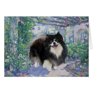 Pomeranian i blomsterträdgård hälsningskort