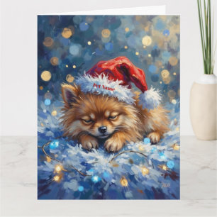 Pomeranian som sover på julgransbelysning med julh kort